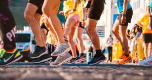 Stock image of multiple runners at a start line from the hip down.